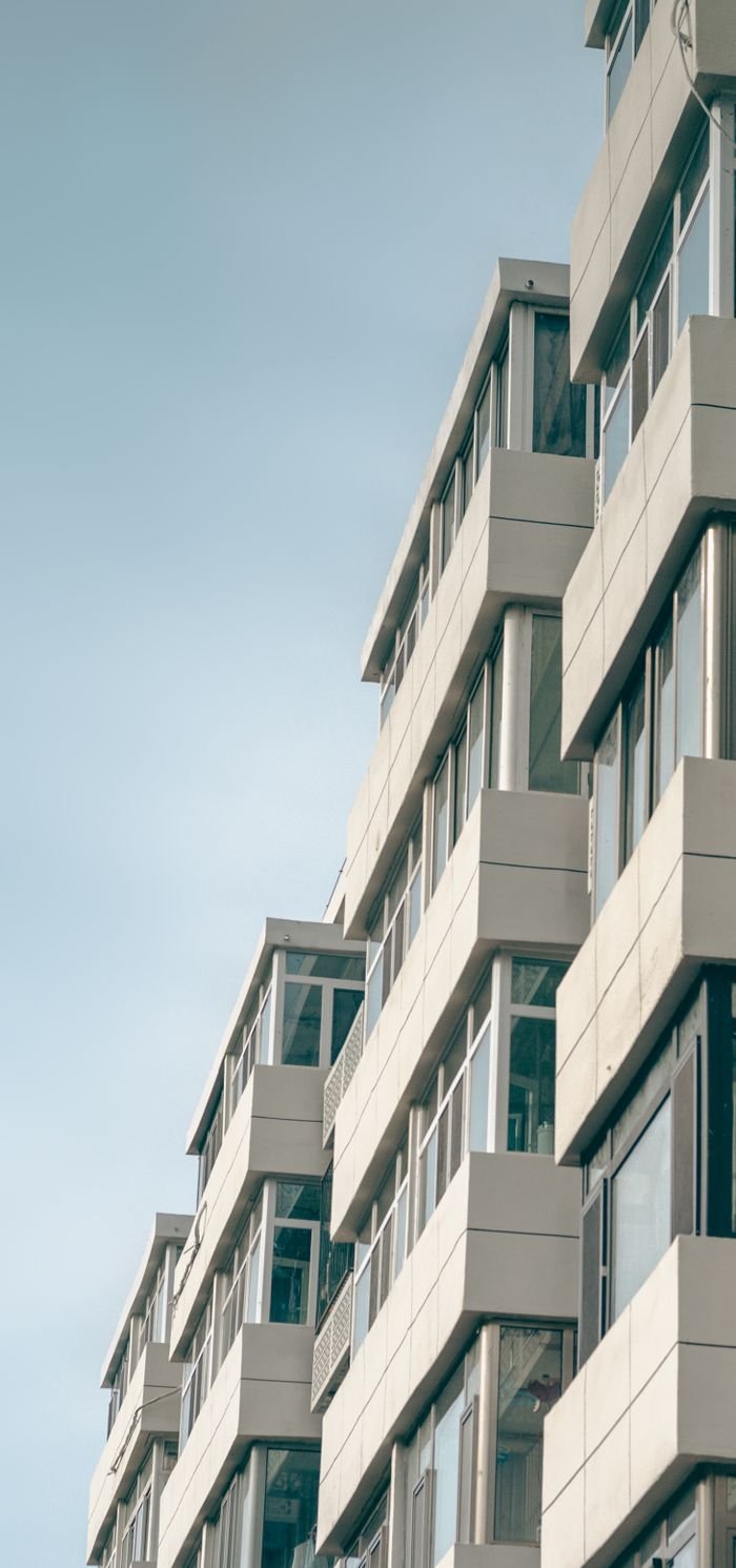 Vertical shot of a modern geometric facade building under a clear sky, emphasizing urban architecture.