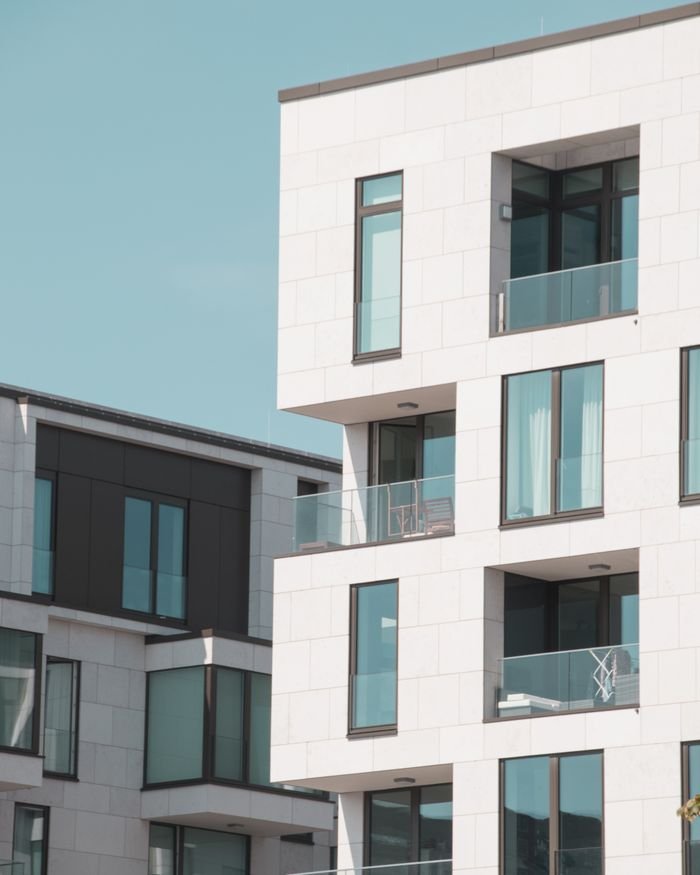 Contemporary apartment buildings in Berlin with elegant white facades and glass balconies.