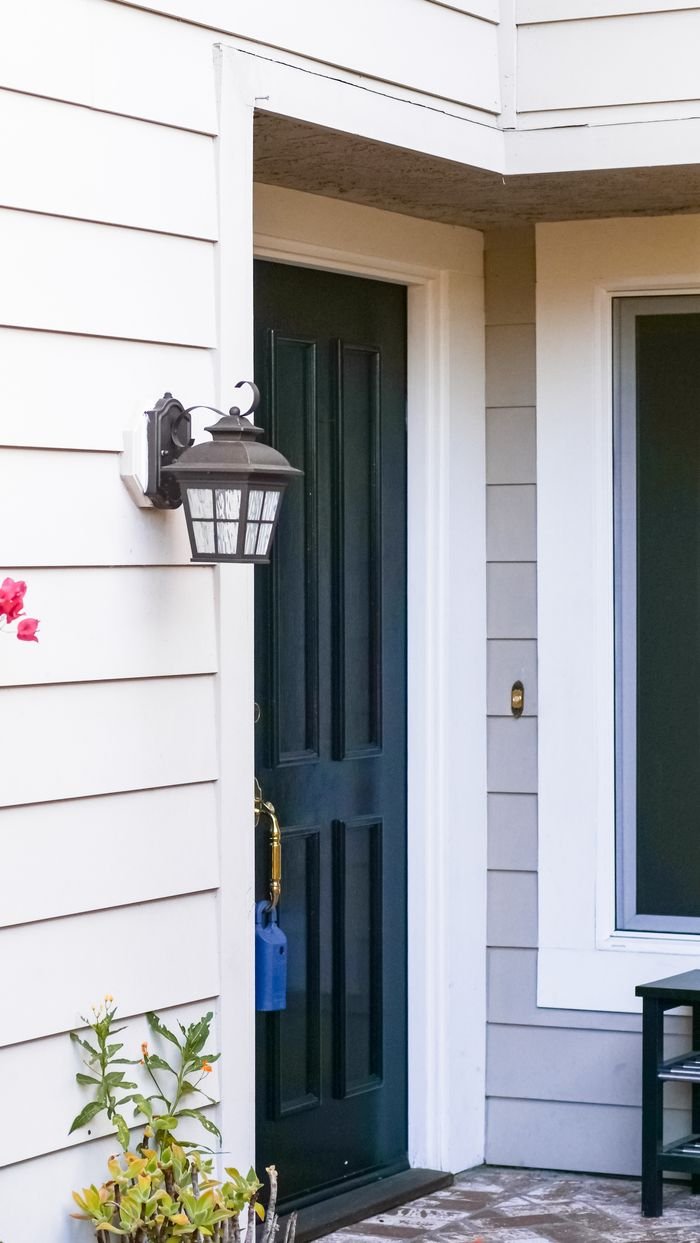 Classic front door with lantern sconce and subtle floral decor, perfect for stock photo use.